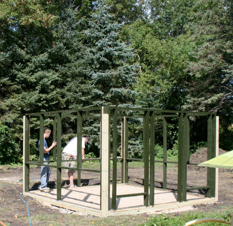 Walls are anchored by corner posts.  Set on a bed of sand and gravel.  